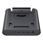 Een driekwart vooraanzicht van een zwart GPD WIN 5 dockingstation, geïsoleerd tegen een zwarte achtergrond. Het dock heeft een reeks poorten aan de voorkant, waaronder USB-C, USB-A en een RJ45 Ethernetpoort. De verzonken bovenkant is ontworpen voor de GPD WIN 5 en bevat een connector voor opladen en data.