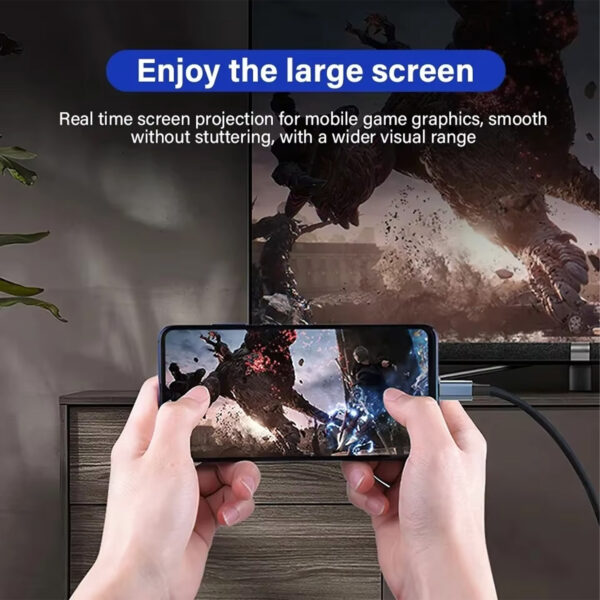 Una imagen de estilo de vida titulada "Disfruta de la gran pantalla" muestra a una persona que sujeta horizontalmente un smartphone mientras juega a un videojuego de alta acción. El teléfono está conectado mediante un cable USB-C a un gran televisor en el fondo, que refleja los mismos gráficos del juego. El texto describe "Proyección de pantalla en tiempo real para gráficos de juegos móviles, fluidos sin tartamudeo, con un mayor alcance visual".
